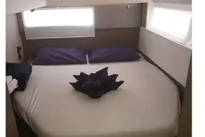 Cozy bedroom in 2022 Leopard 45 yacht with neatly arranged bed and soft lighting.
