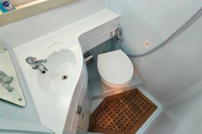 Compact bathroom in 1989 Princess 35 Flybridge yacht with sink and toilet.