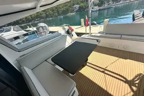 2024 Lagoon 42 yacht deck with seating and table, docked by serene waters.