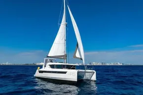 Sailing catamaran Leopard 46, 2025 model, cruising on open sea under clear blue sky.