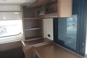 Interior of 2020 Lagoon 46 yacht with wooden cabinetry and large window.
