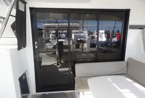 Lagoon 42 catamaran 2020 model with sliding glass doors and outdoor seating area.