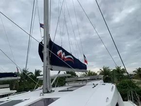 Sailing catamaran Leopard 45, 2021 model, with sails down, under cloudy skies.