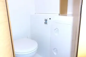 Bathroom interior of a 2017 Lagoon 42 catamaran, featuring a compact toilet and storage area.