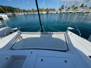 Leopard 40 catamaran docked in a marina, surrounded by sailboats and palm trees.