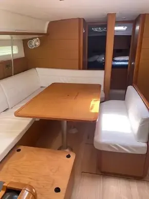 Interior of 2017 Jeanneau Sun Odyssey 519 sailboat with dining area and white seating.