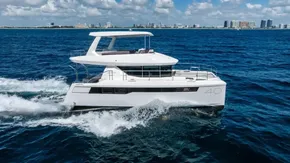 2025 Leopard 40 Powercat cruising on open water with city skyline in background.