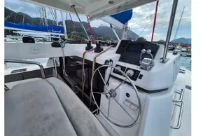 Helm of 2020 Leopard 45 catamaran with modern controls, docked in scenic marina.