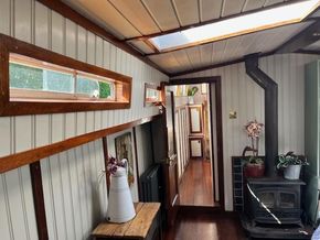 Interior of a 1901 Classic Dutch Barge with wood paneling and a cozy stove.