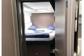 Interior cabin view of 2022 Leopard 45 yacht, featuring a cozy bed and modern design.