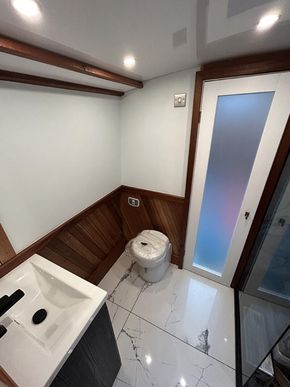spacious bathroom, with Full size walk in shower, solid marble floor, ceramic loo, sink with integrated storage.