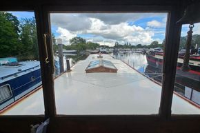 View from inside a 1926 Dutch Barge Luxemotor, overlooking a serene marina.