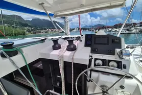 Helm of 2021 Leopard 45 catamaran with marina and mountain views in the background.