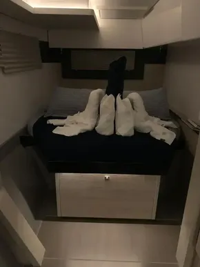 Cozy cabin bed in a 2020 Leopard 40 catamaran with towel art.