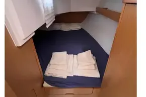 Cozy cabin interior of 2018 Beneteau Oceanis 48 sailboat with bed and linens.
