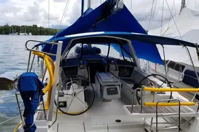 2013 Beneteau Oceanis 41 sailboat with blue canopy, docked in a serene marina setting.