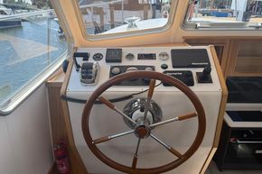 2024 Piper 12c boat helm with steering wheel and navigation controls, docked at marina.