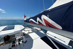 2022 Leopard 42 catamaran sailing on calm ocean under clear blue sky.
