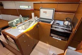 Modern kitchen interior of 2020 Jeanneau Sun Odyssey 389 yacht with stove and sink.