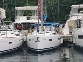 2020 Jeanneau Sun Odyssey 410 sailboat docked between yachts in a marina.