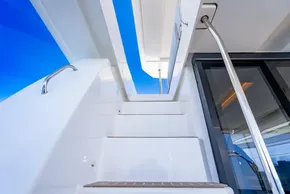 Staircase on 2025 Leopard 40 Powercat yacht, leading to upper deck under clear blue sky.