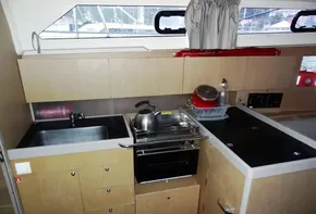 Modern kitchen in 2017 Beneteau Oceanis 41 sailboat with sink, stove, and storage.