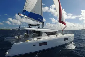 2020 Lagoon 42 catamaran sailing on open water under clear skies.