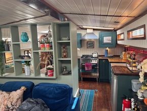 Interior of a 1901 Classic Dutch Barge with cozy kitchen and living area.