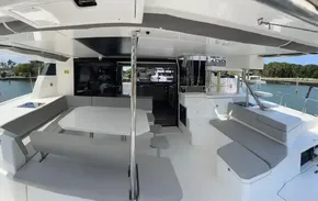 Spacious deck area of a 2020 Leopard 50 catamaran with seating and dining table.