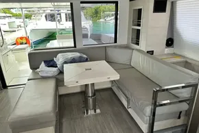 Interior of 2021 Leopard 50 yacht with modern seating and table, docked at marina.
