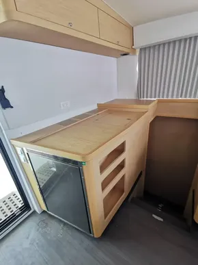 Interior of 2020 Lagoon 42 yacht with compact kitchen area and wooden cabinetry.