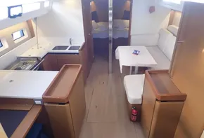 Interior of 2019 Jeanneau Sun Odyssey 440 yacht, featuring kitchen and seating area.