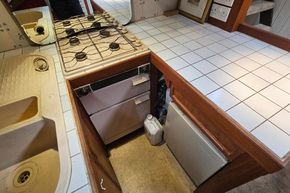 1926 Dutch Barge Luxemotor kitchen with stove, sink, and tiled countertop.
