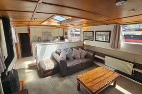 Luxemotor Dutch Barge 1926 interior with cozy living area, leather sofa, and wooden accents.