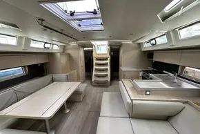 Luxurious interior of 2023 Beneteau Oceanis 51.1 yacht with modern kitchen and seating area.