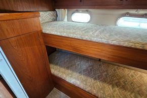 Interior of 1989 Princess 35 Flybridge with wooden bunk beds and porthole windows.